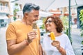 Middle age couple smiling happy eating ice cream at street of city Royalty Free Stock Photo