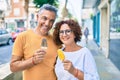 Middle age couple smiling happy eating ice cream at street of city Royalty Free Stock Photo