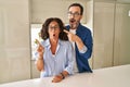 Middle age couple standing together surprised pointing with finger to the side, open mouth amazed expression Royalty Free Stock Photo