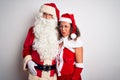 Middle age couple wearing Santa costume hugging over isolated white background depressed and worry for distress, crying angry and Royalty Free Stock Photo