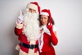 Middle age couple wearing Santa costume hugging over isolated white background Pointing up looking sad and upset, indicating Royalty Free Stock Photo