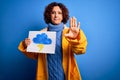 Middle age curly hair woman wearing rain coat holding banner with cloud and thunder with open hand doing stop sign with serious