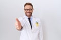 Middle age doctor man with beard wearing white coat smiling friendly offering handshake as greeting and welcoming Royalty Free Stock Photo