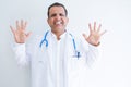 Middle age doctor man wearing stethoscope and medical coat over white background showing and pointing up with fingers number ten Royalty Free Stock Photo