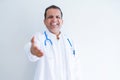Middle age doctor man wearing stethoscope and medical coat over white background smiling friendly offering handshake as greeting Royalty Free Stock Photo