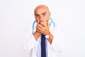 Middle age doctor man wearing stethoscope and tie standing over isolated white background shocked covering mouth with hands for Royalty Free Stock Photo