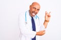 Middle age doctor man wearing stethoscope and tie standing over isolated white background smiling with happy face winking at the Royalty Free Stock Photo