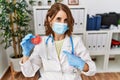 Middle age doctor woman wearing safety mask holding virus toy pointing finger to one self smiling happy and proud Royalty Free Stock Photo