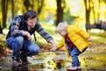 Middle age father playing with his toddler son together in a autumn park Royalty Free Stock Photo