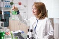 Middle age female biologist in a laboratory looking at chemical test tube