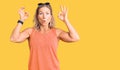 Middle age fit blonde woman wearing casual summer clothes and sunglasses looking surprised and shocked doing ok approval symbol Royalty Free Stock Photo