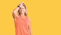 Middle age fit blonde woman wearing casual summer clothes and sunglasses surprised with hand on head for mistake, remember error Royalty Free Stock Photo