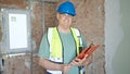 Middle age grey-haired man builder smiling confident reading document on clipboard at construction site Royalty Free Stock Photo