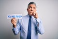 Middle age grey-haired man fired with problems holding paper with you are fired message serious face thinking about question, very Royalty Free Stock Photo