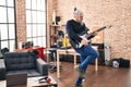 Middle age grey-haired man musician playing electrical guitar dancing at music studio Royalty Free Stock Photo
