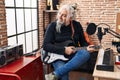 Middle age grey-haired man musician smiling confident playing electrical guitar at music studio Royalty Free Stock Photo