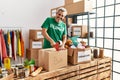 Middle age grey-haired man volunteer smiling confident packing books cardboard box at charity center Royalty Free Stock Photo