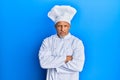 Middle age grey-haired man wearing professional cook uniform and hat skeptic and nervous, disapproving expression on face with Royalty Free Stock Photo