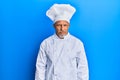 Middle age grey-haired man wearing professional cook uniform and hat skeptic and nervous, frowning upset because of problem Royalty Free Stock Photo