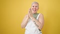 Middle age grey-haired woman smiling confident clapping applause over isolated yellow background