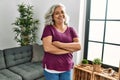 Middle age grey-haired woman smiling happy standing with arms crossed gesture at home Royalty Free Stock Photo