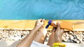 Middle age hand with sun cream on her legs. she is holding sunscreen bottle in the poolside as applying moisturizing lotion on Royalty Free Stock Photo