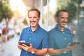 Middle age handsome businessman using tablet smiling on the street Royalty Free Stock Photo