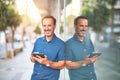 Middle age handsome businessman using tablet smiling on the street Royalty Free Stock Photo
