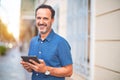 Middle age handsome businessman using tablet smiling on the street Royalty Free Stock Photo