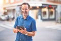 Middle age handsome businessman using tablet smiling on the street Royalty Free Stock Photo