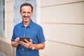 Middle age handsome businessman using tablet smiling on the street Royalty Free Stock Photo