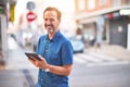 Middle age handsome businessman using tablet smiling on the street Royalty Free Stock Photo