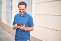 Middle age handsome businessman using tablet smiling on the street Royalty Free Stock Photo