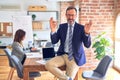 Middle age handsome businessman wearing glasses sitting on desk at the office relax and smiling with eyes closed doing meditation Royalty Free Stock Photo