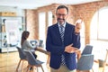 Middle age handsome businessman wearing glasses   standing at the office with a big smile on face, pointing with hand and finger Royalty Free Stock Photo