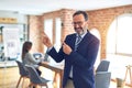 Middle age handsome businessman wearing glasses standing at the office smiling and looking at the camera pointing with two hands Royalty Free Stock Photo