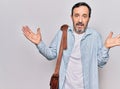 Middle age handsome businessman wearing leather bag over isolated white background clueless and confused with open arms, no idea Royalty Free Stock Photo