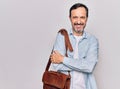 Middle age handsome businessman wearing leather bag over isolated white background happy face smiling with crossed arms looking at Royalty Free Stock Photo