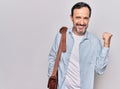 Middle age handsome businessman wearing leather bag over isolated white background pointing thumb up to the side smiling happy Royalty Free Stock Photo