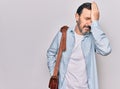 Middle age handsome businessman wearing leather bag over isolated white background surprised with hand on head for mistake, Royalty Free Stock Photo