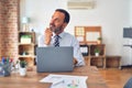 Middle age handsome businessman wearing tie sitting using laptop at the office with hand on chin thinking about question, pensive Royalty Free Stock Photo