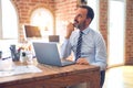 Middle age handsome businessman wearing tie sitting using laptop at the office with hand on chin thinking about question, pensive Royalty Free Stock Photo