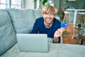 Middle age handsome caucasian man relaxing at home doing online shopping using credit card on computer laptop Royalty Free Stock Photo