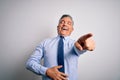 Middle age handsome grey-haired business man wearing elegant shirt and tie laughing at you, pointing finger to the camera with Royalty Free Stock Photo