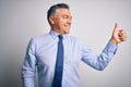 Middle age handsome grey-haired business man wearing elegant shirt and tie Looking proud, smiling doing thumbs up gesture to the Royalty Free Stock Photo