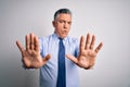 Middle age handsome grey-haired business man wearing elegant shirt and tie Moving away hands palms showing refusal and denial with