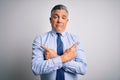 Middle age handsome grey-haired business man wearing elegant shirt and tie Pointing to both sides with fingers, different