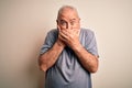 Middle age handsome hoary man wearing t-shirt standing over isolated white background shocked covering mouth with hands for Royalty Free Stock Photo