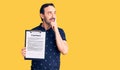 Middle age handsome man holding clipboard with contract document serious face thinking about question with hand on chin,