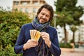 Middle age handsome man holding norwegian krone banknotes outdoors at the park